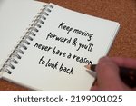 Keep moving forward and you will never have a reason to look back text written on white notebook. Inspirational concept.