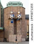 Small photo of Helsinki, Finland - Jun 20th 2021: "Light bringer" -statues near Helsinki railway station are dressed to support Finnish soccer team in European Championships.