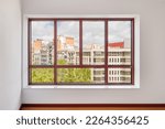Small photo of Large window in the room with a wide window sill. Window in plastic brown frame. Through the window you can watch what is happening on the street and the neighboring houses opposite.