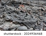 Small photo of Natural background from solidified volcanic lava. Rope lava is the result of slowing forward flow and accelerating backward flow. Crumpled volcanic stones of Kamchatka Russia