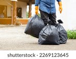 Closeup man holds black plastic bag that contains garbage inside. Concept , Waste management. Environment problems. Daily chores. Throw away rubbish .                        
