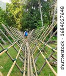 Small photo of SARAWAK CULTURAL VILLAGE, SARAWAK, MALAYSIA - JULY 14, 2019: Tourists crossed over Bidayuh bamboo bridge to Bidayuh longhouse in Sarawak Cultural Village.