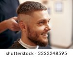 Small photo of Barber shaving caucasian man in barber shop