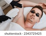 Young man receiving epilation in beauty center. laser hair removal procedure