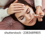 cosmetologist removes glue cotton strip under eye. Eyelash extension procedure
