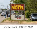 Small photo of Marienville, Pennsylvania, USA June 10, 2023 The Pioneer Motel sign on Chestnut Street advertising that Bigfoot sleeps there as seen on a sunny spring day