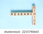 Small photo of Research ethics concept. Crossword puzzle flat lay typography in blue background