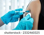 Doctor making a vaccination into patient with needle getting immune vaccine at arm for flu shot, coronavirus protective of epidemic.