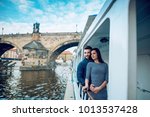 Happy young couple in love, floating on a ship near the Charles bridge at Prague