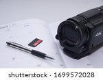 4K video camera pen  and memory card on white paper