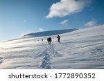 Group of mountaineer climbing on snowy hill and blue sky in winter at Lofoten Islands, Norway
