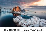 Beautiful landscape of aerial view of snowy mountain and fishing village on coastline in winter at Lofoten Islands, Norway