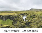 Waterfall in the beautiful landscape in Icelandic environment during cloudy, misty day