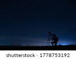 Small photo of Human silhouette and telescope, a woman looks through a telescope at the starry sky. Night sky, stars, long exposure, astronomy