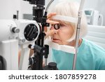 Senior woman eyesight test with binocular slit-lamp. Checking retina of a female eye close-up. Ophthalmology clinic