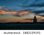 South Dakota Badlands. Woman silhouetted against a beautiful sunset on mountain top.   