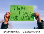 Hands holding a poster with Make love, not war