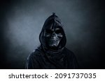 Small photo of Grim reaper over dark misty background
