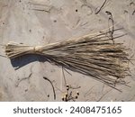 Small photo of A broom of straw lies on the ground in the yard of a village house. Natural organic wooden broom. Cleaning tool for home. Handmade Whisk Sweeping Broom for Cleaning Dustpan Indoor-Outdoor.