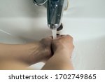 Washing hands under flowing tap ...