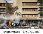 Small photo of Black Lives Matter protest riot vandalism, looting aftermath concept, flaming police car smashed, overturned with black lives matter text slogan message on building. Excessive force, police brutality