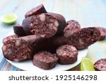 Small photo of Black pudding traditional Colombian food, accompanied by pepper and lemon on wooden background