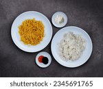 Small photo of Plates of rice and instant noodles on a dark background. Unhealthy carbohydrates combo. A kind of comfort food in Indonesia. Nasi and mie goreng. Flat lay shot.