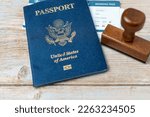 Small photo of US passport and stamp on wooden background. Safe journey with necessary documentation. Top view. Copy space. Your Key to International Travel