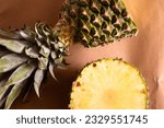 Small photo of pineapple cut in half crosswise on a light brown background