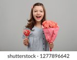 Small photo of Happy girl with flowers and lollipop. Present from a heartthrob. Date on Valentine's Day.