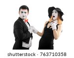 Small photo of Emotional acting of two mimes. Actors, dressed in 20's style, playing a melodramatic sketch. Man breaks up with his woman, leaving her heartbroken.