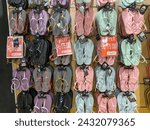 Small photo of Yogyakarta, Indonesia - January 15, 2024: Various rubber flip flops hanging on display at an footwear store. Vibrant summer flip flop sandals.