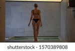 Small photo of Back view of an young woman with firm and slim body is entering in a whirlpool bath tube in a luxury wellness center.