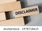 Small photo of DISCLAIMER - word on a wooden bar on a gray background. Business concept
