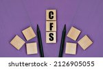 Small photo of CFS ( Consolidated Financial Statement) - acronym on wooden cubes with pencils on a purple background