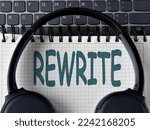Small photo of REWRITE - word on white notepad with keyboard and headphone background