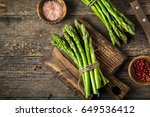 banches of fresh green asparagus on wooden background, top view