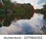 Small photo of Edwardsville, Illinois USA - November ‎2, ‎2021: Beautiful Autumn view with trees and clouds reflected on the Tower Lake at Botanical Gardens of SIUE. Southern Illinois University Edwardsville Campus