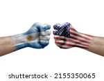 Two hands punch to each others on white background. Country flags painted fists, conflict crisis concept between argentina and usa