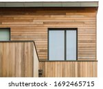 Modern wooden facade with flat roof and aluminium window
