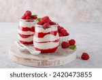 Small photo of Vanilla white chocolate mousse, trifle, panna cotta or parfait with raspberry sauce in a glass jar. Sweet summer dieting dessert