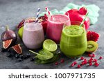 Colorful smoothie, healthy detox vitamin diet or vegan food concept, fresh vitamins, breakfast drink with spinach, pomegranate, figs and blueberries