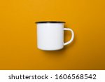 One white enamel cup with a black rim on a yellow uniform background, light an soft shadows, use es virtual meeting background or template