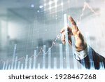 Multi exposure of businessman hand presses on virtual creative financial chart hologram on blurred office background, research and analytics concept