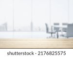 Empty office wooden desktop with empty space on modern boardroom with large window background, closeup, mock up