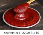 Small photo of Close-up and top angle view of red pepper paste with spatula on a jar and wood floor, South Korea
