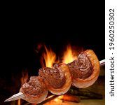 Small photo of Barbecued Picanha barbecue with blurred fire in the background. This form of barbecue is widely consumed throughout Brazil.