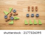 Small photo of Flat lay of rearrange vary shape and color geometry block from left to right on wooden table background. Renovation, arrange category in business, company and education concept.