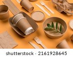 Small photo of Eco-friendly paper tableware - kraft paper food packaging on orange background. Street food paper packaging, recyclable paperware, zero waste packaging concept. Flat lay, mockup image