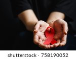 Aids ribbon on hands, hiv, red ribbon symbol of struggle,  on dark background